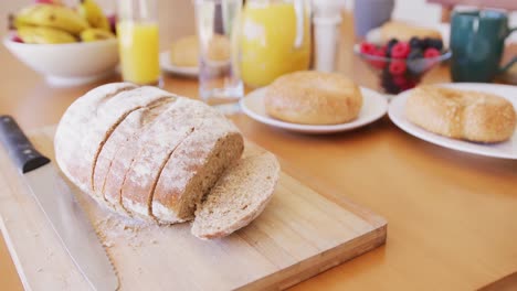 close up of fresh bread and fruit on breakfast with coffee and orange juice on table