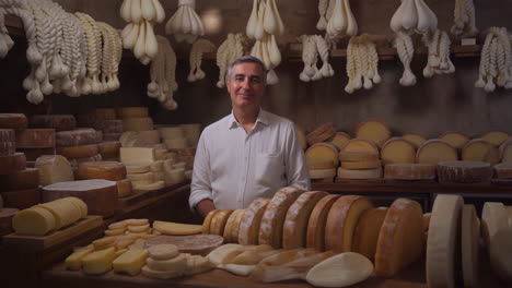 man in a cheese shop with a variety of cheeses