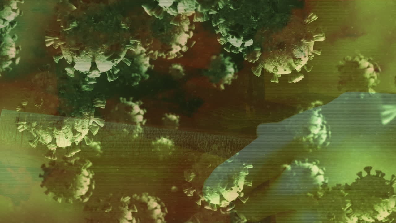 성경을 들고 있는 손의 클로즈업에 대해 떠다니는 여러 개의 코로나19 세포