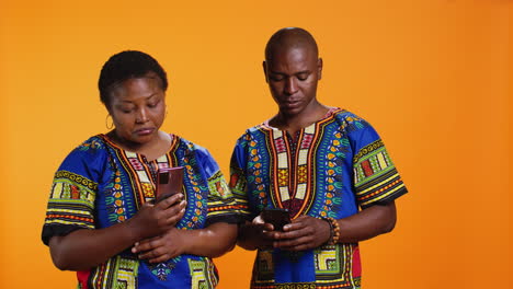 ethnic people in traditional clothes checking smartphone apps