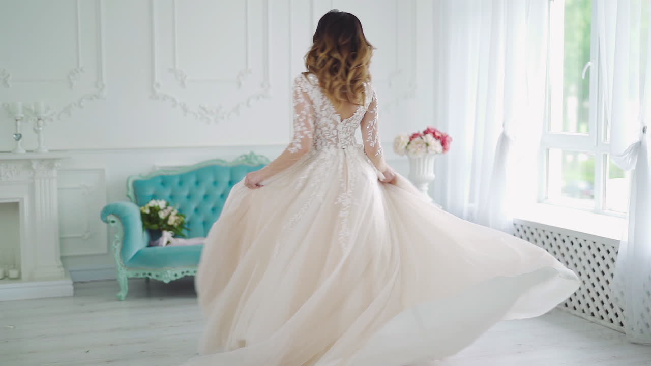 Beautiful bride at the light room. Bride in beautiful dress indoors in white studio interior like at home