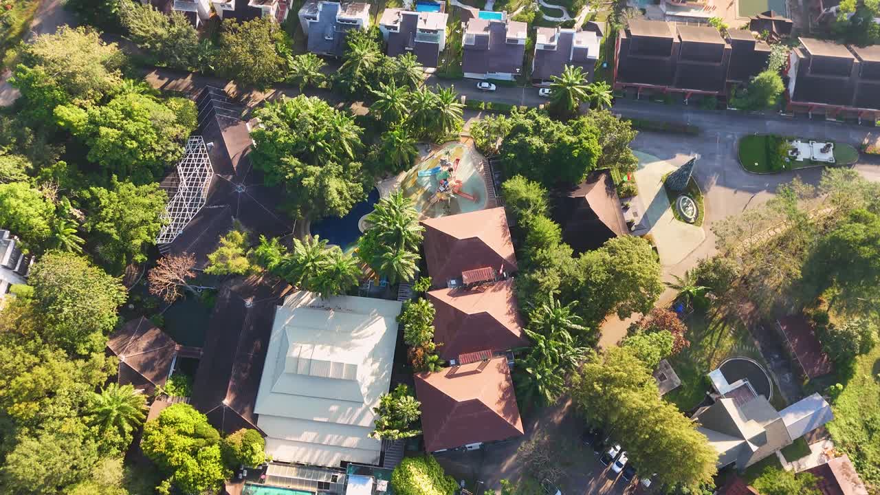 Plano aéreo de dron en picado se mueve sobre un resort de lujo rodeado de exuberante vegetación de selva tropical