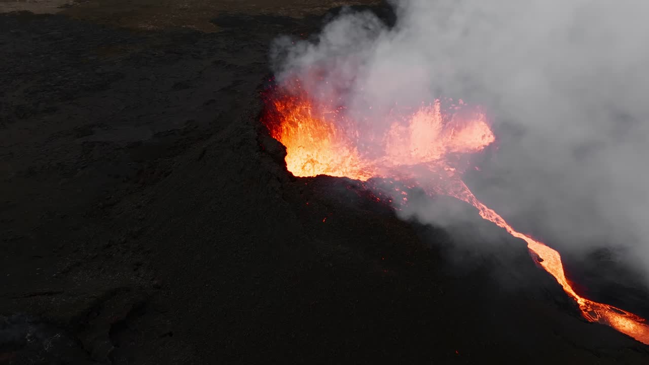 Lava incandescente e brillante che si infrange contro il paesaggio vulcanico nero e arido a contrasto