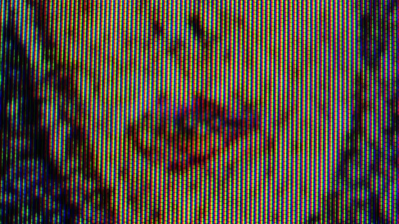 Pixels in the working old analog TV screen close up. Red, blue and green dot create the image on the screen. Macro. Close up