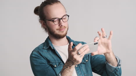 caucasian young man watching video on smartphone.