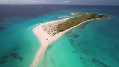la gente camina en el banco de arena tropical, el movimiento del avión no tripulado hacia atrás descenso, cayo de agua los rocas