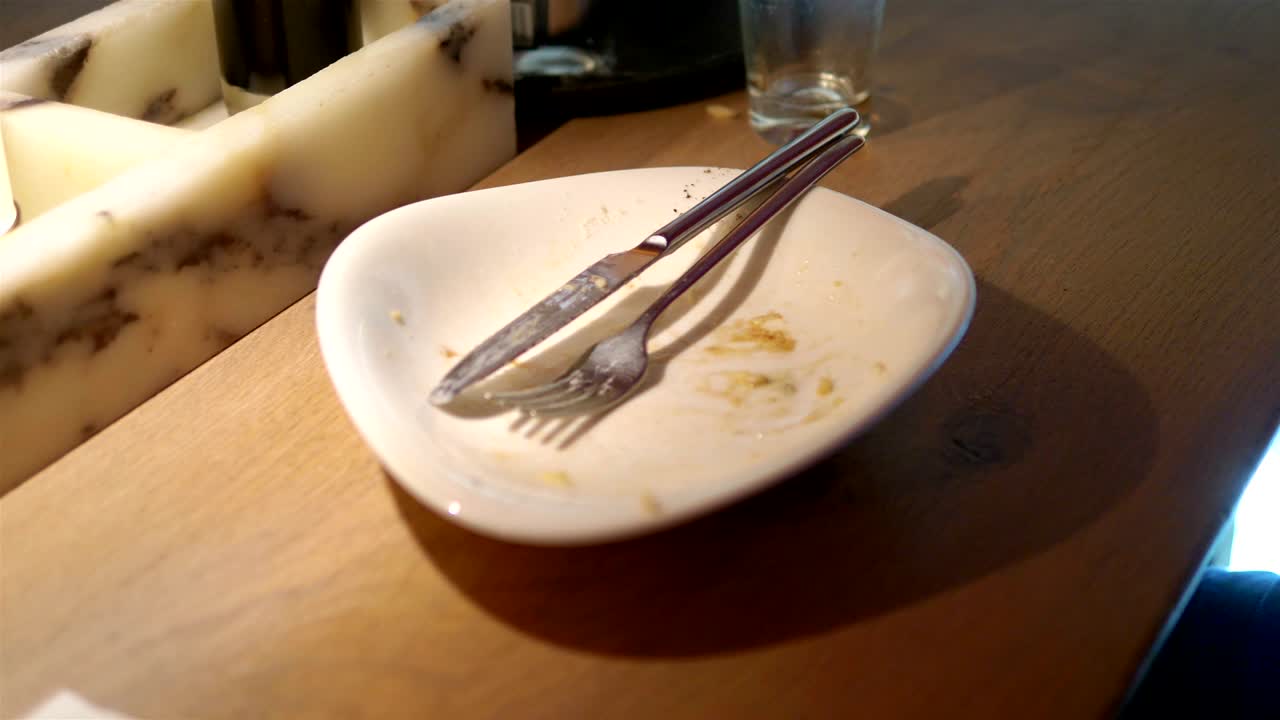 Throwing napkin on thirty plate after eating in 4k slow motion