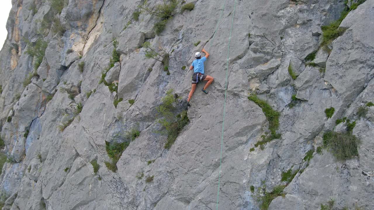 Close circular drone footage of a man top-rope climbing in the Pyrenees moutains at Tarascon sur Ari&egrave;ge