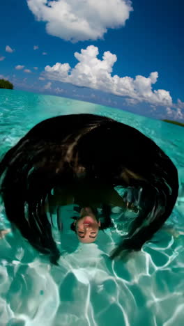 joyful woman splashing water in a tropical ocean