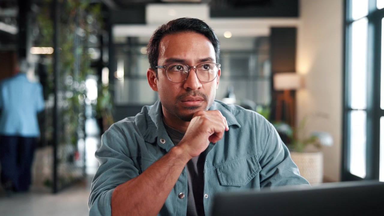 Focused Professional Man Working on Laptop in Modern Office
