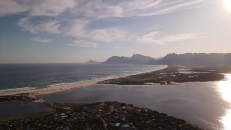 Lagoon-river-mouth-connecting-with-the-ocean-and-spectacular-mountains-in-the-distance