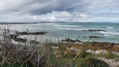 waves running out onto rocky beach, dramatic skies after rains