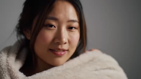 a serene moment captured: embracing warmth and comfort in a cozy setting with a gentle smile and soft fabrics