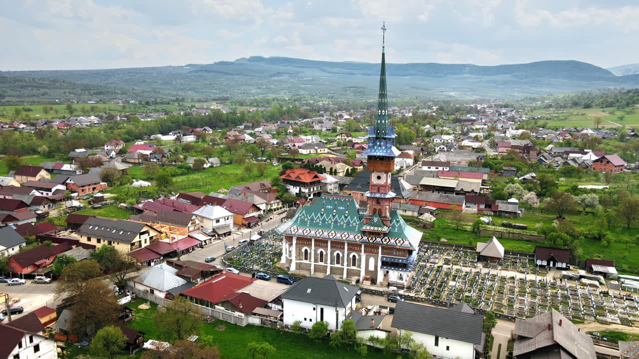 Letecký dronový pohled na Veselý hřbitov v rumunské obci Sapanta. Kostel a hřbitov, obytné budovy kolem něj