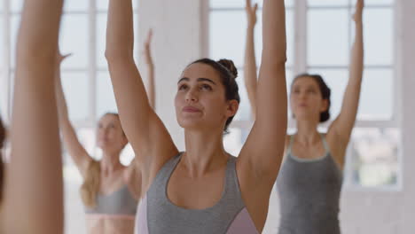 yoga-class-beautiful-caucasian-woman-practicing-warrior-pose-fitness-instructor-teaching-group-of-multi-ethnic-women-healthy-meditation-practice-in-workout-studio