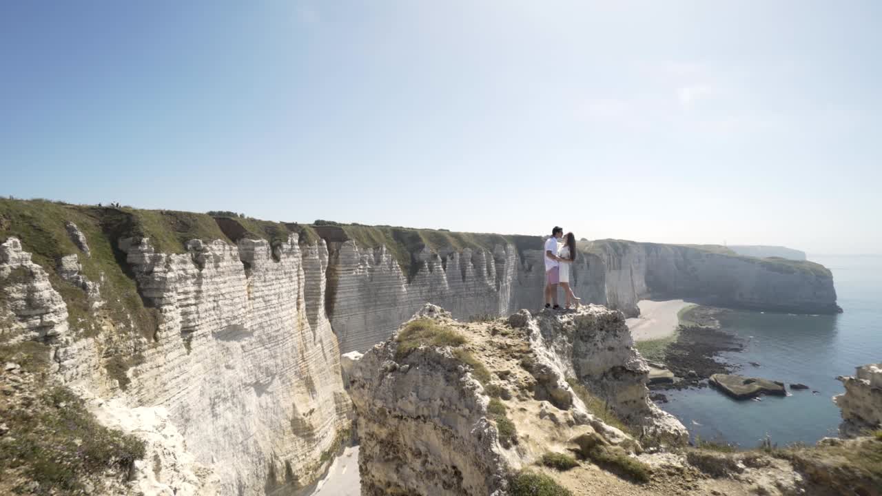una pareja en los acantilados con vistas al océano.
