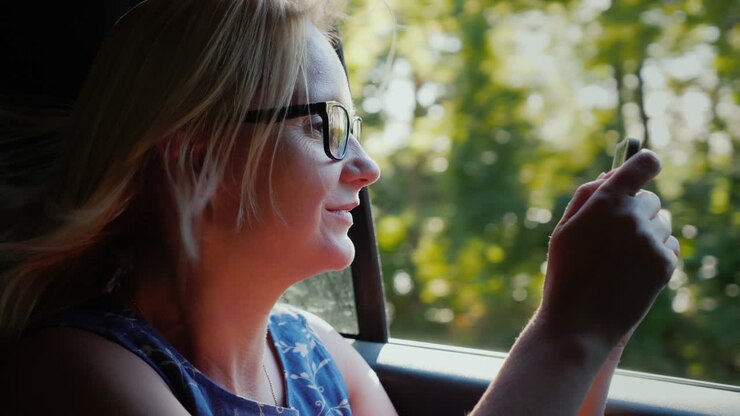 Donna che scatta fotografie dal finestrino dell'auto
