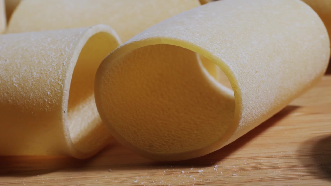 Close Up of Uncooked Paccheri Pasta on a Wooden Board