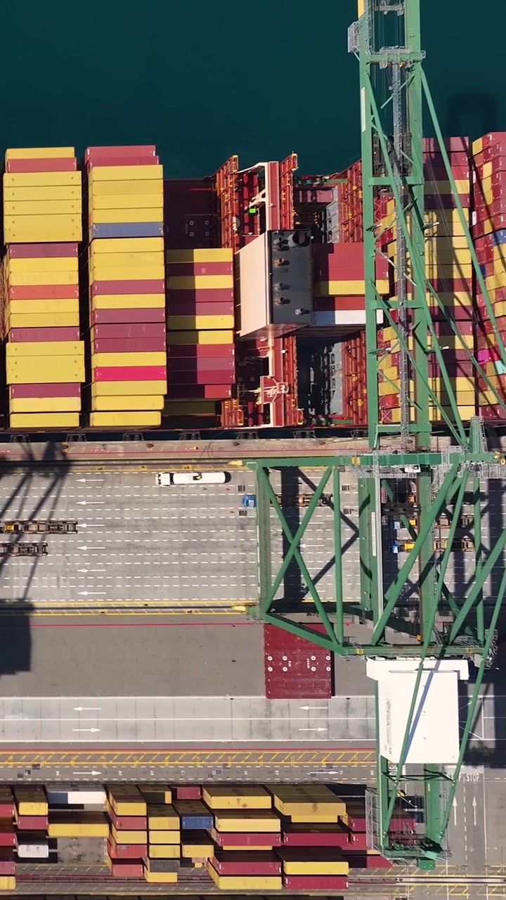 Container terminal shows a busy operation with cranes unloading and loading shipping containers.