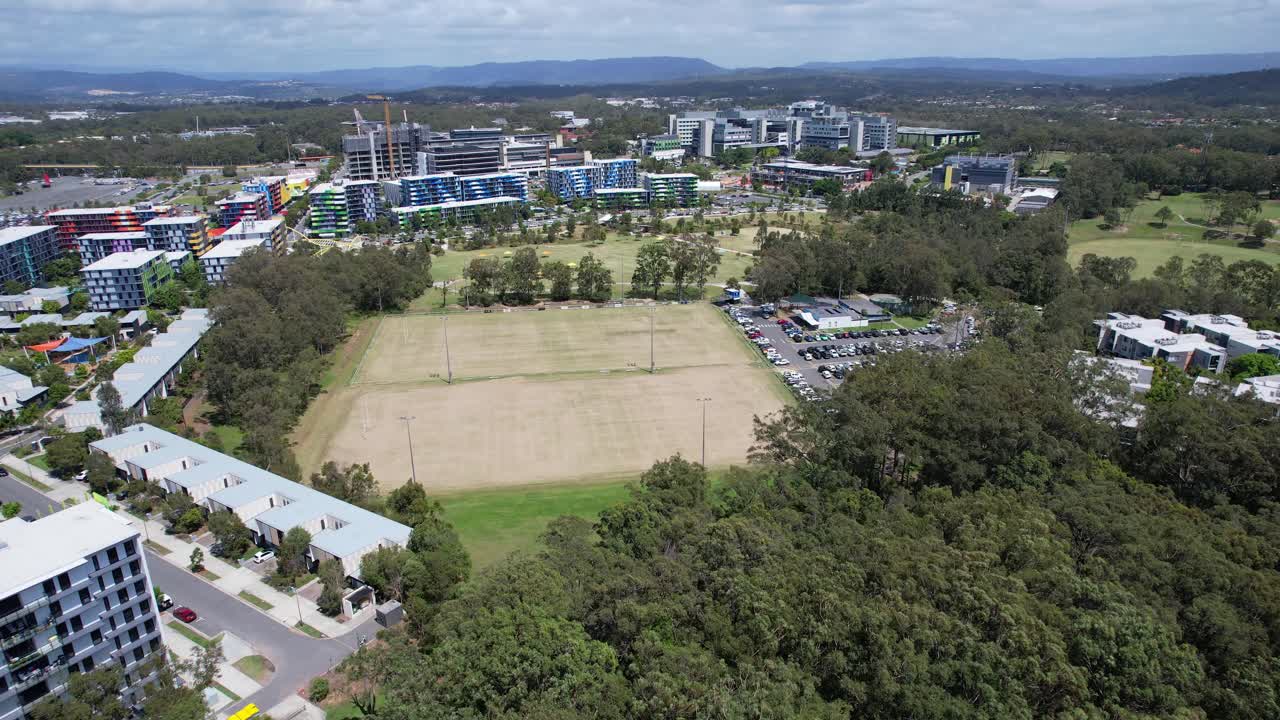 Aerial View of a Modern Suburb with Sports Field and Residential Buildings