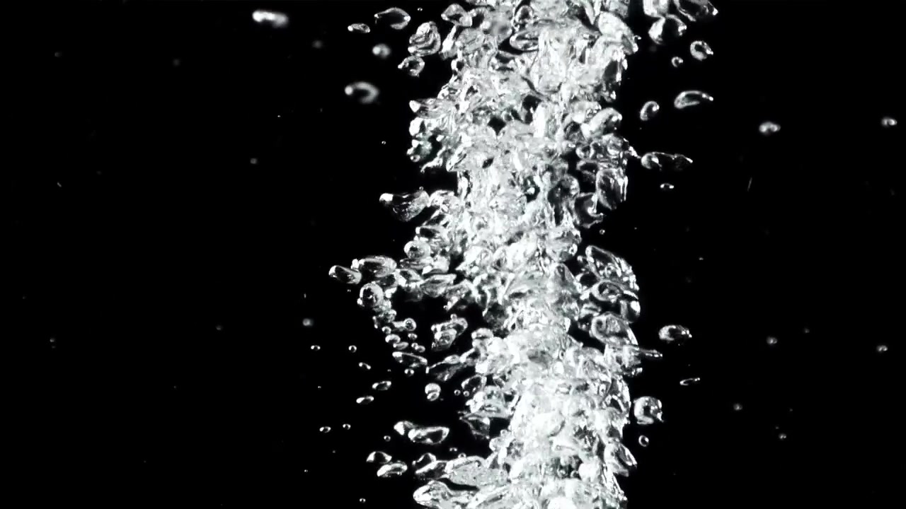 Burbujas de agua claras subiendo contra un fondo negro.