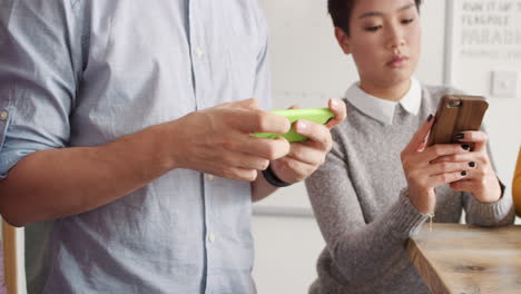 diverse group of business people using smart phone touch screen digital device to access cloud computing social media app for connected data sharing