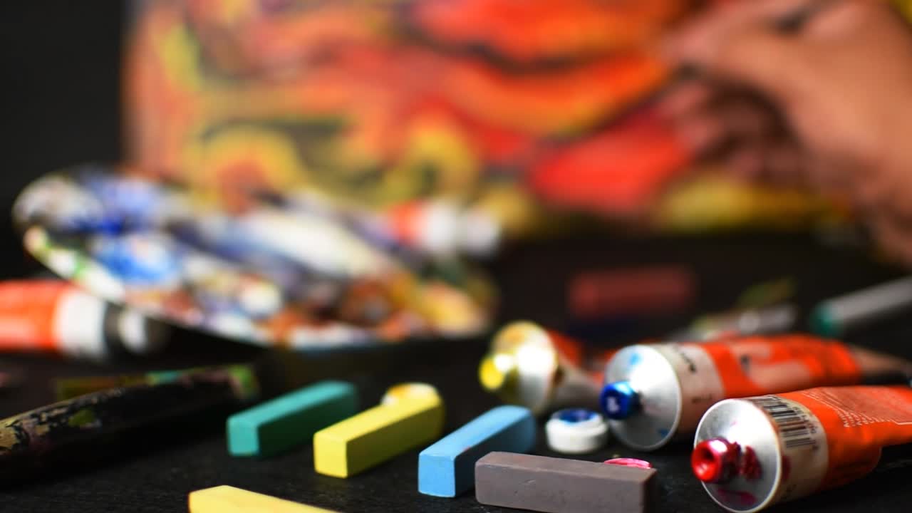 Artist Painting in Studio with Colorful Paints and Pastels