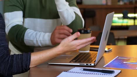 Executive-discussing-over-laptop-in-office-cafeteria-4k