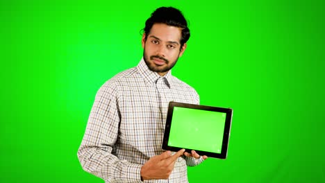 chico usando móvil - tableta con pantalla verde y fondo verde chico indio con pantalla verde