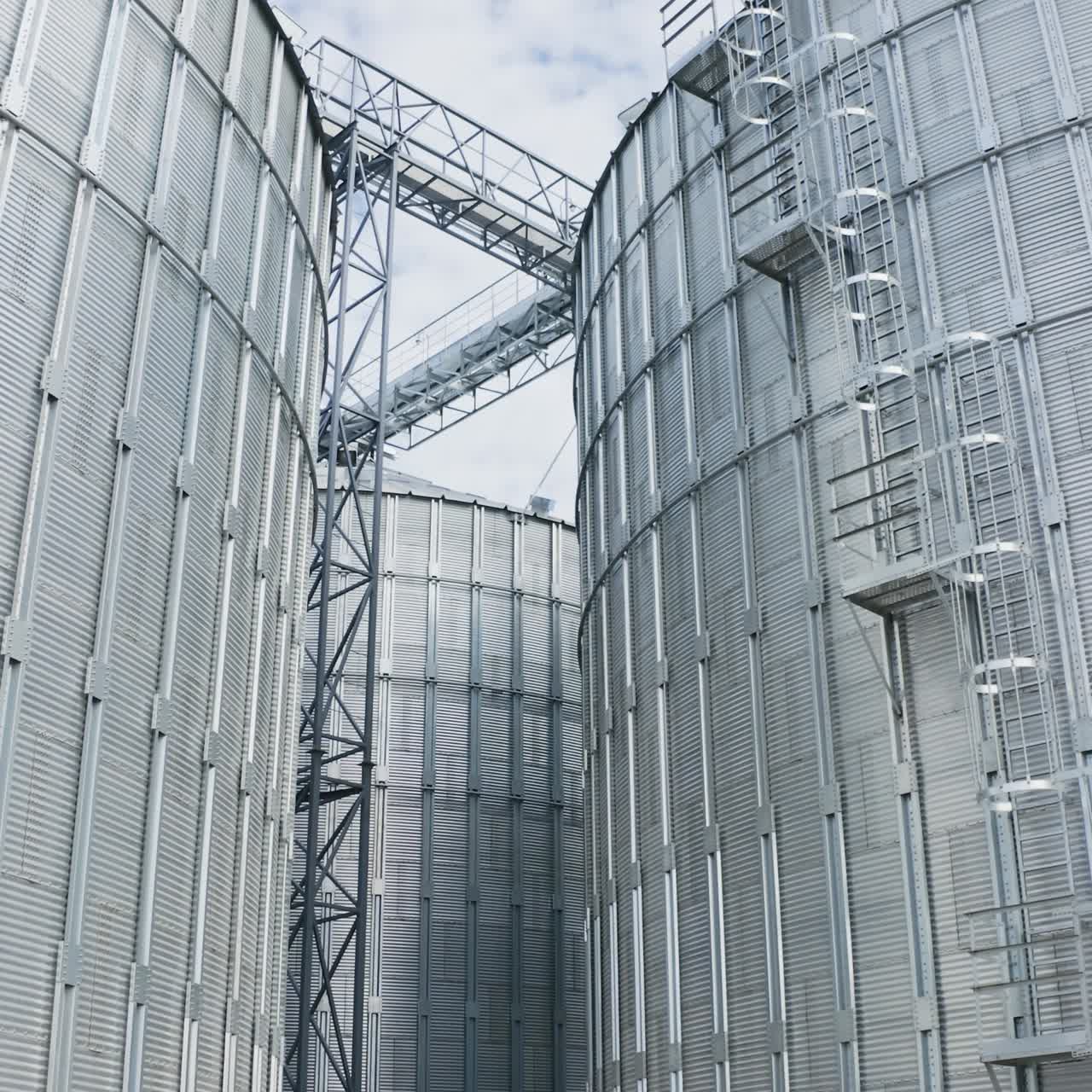 Farming grain agricultural tanks. Big industrial steel elevator containers