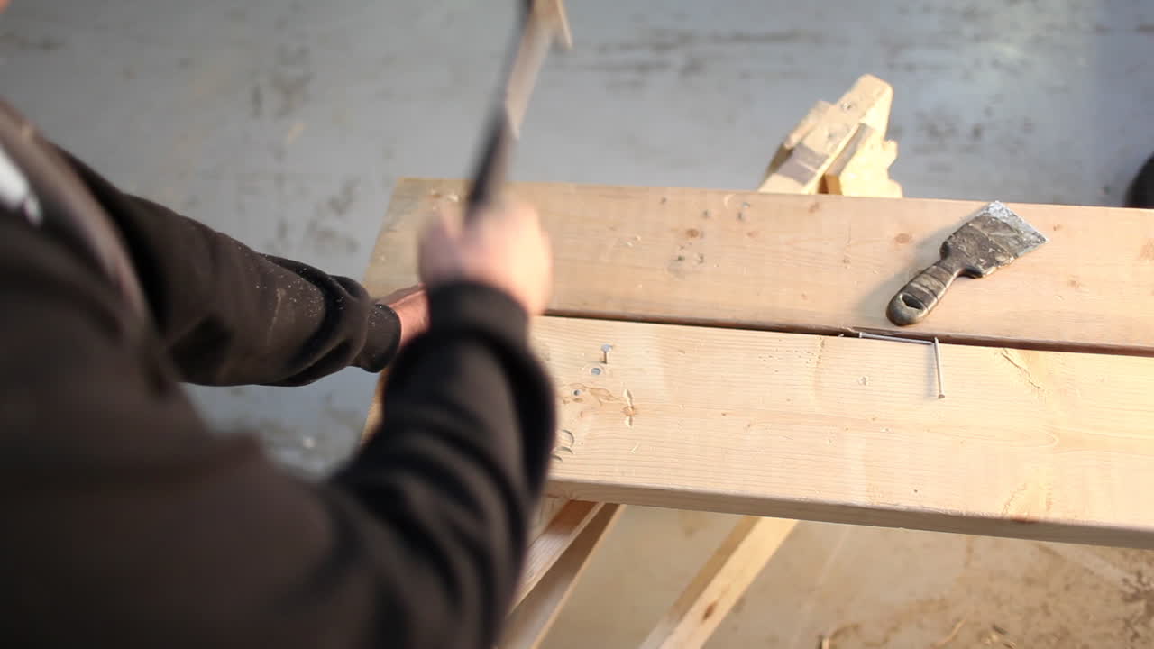 una toma de gran angular de una persona martillando clavos en una tabla de madera