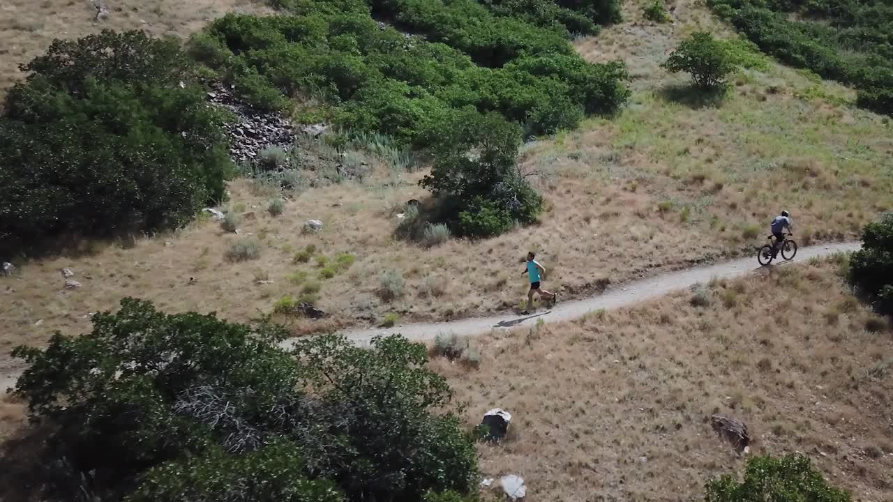 disparo de un dron siguiendo a un hombre activo corriendo por los senderos de montaña al aire libre de wasatch sobre draper city, utah