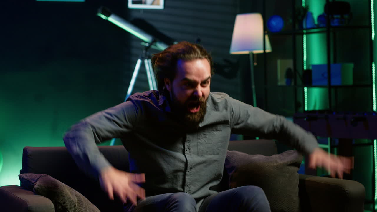 un partidario enojado furioso mientras veía la transmisión deportiva, arrojando almohadas a la televisión