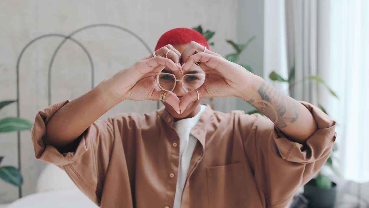 joven alegre linda mujer afroamericana haciendo símbolo del corazón con los dedos