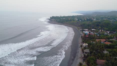 el salvador beach, surf city, la libertad beach houses panoramic drone view of the shoreline early in the morning with haze