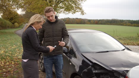 two drivers exchanging insurance details after car accident