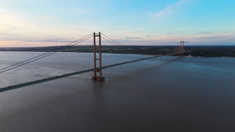 Der-Reiz-Der-Dämmerung:-Eine-Luftaufnahme-Der-Humber-Bridge-Unter-Der-Untergehenden-Sonne,-Wo-Sich-Autos-Mit-Rhythmischer-Eleganz-Bewegen