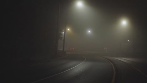Vehicle-Traveling-Along-Suburban-Road-On-A-Foggy-Night---wide