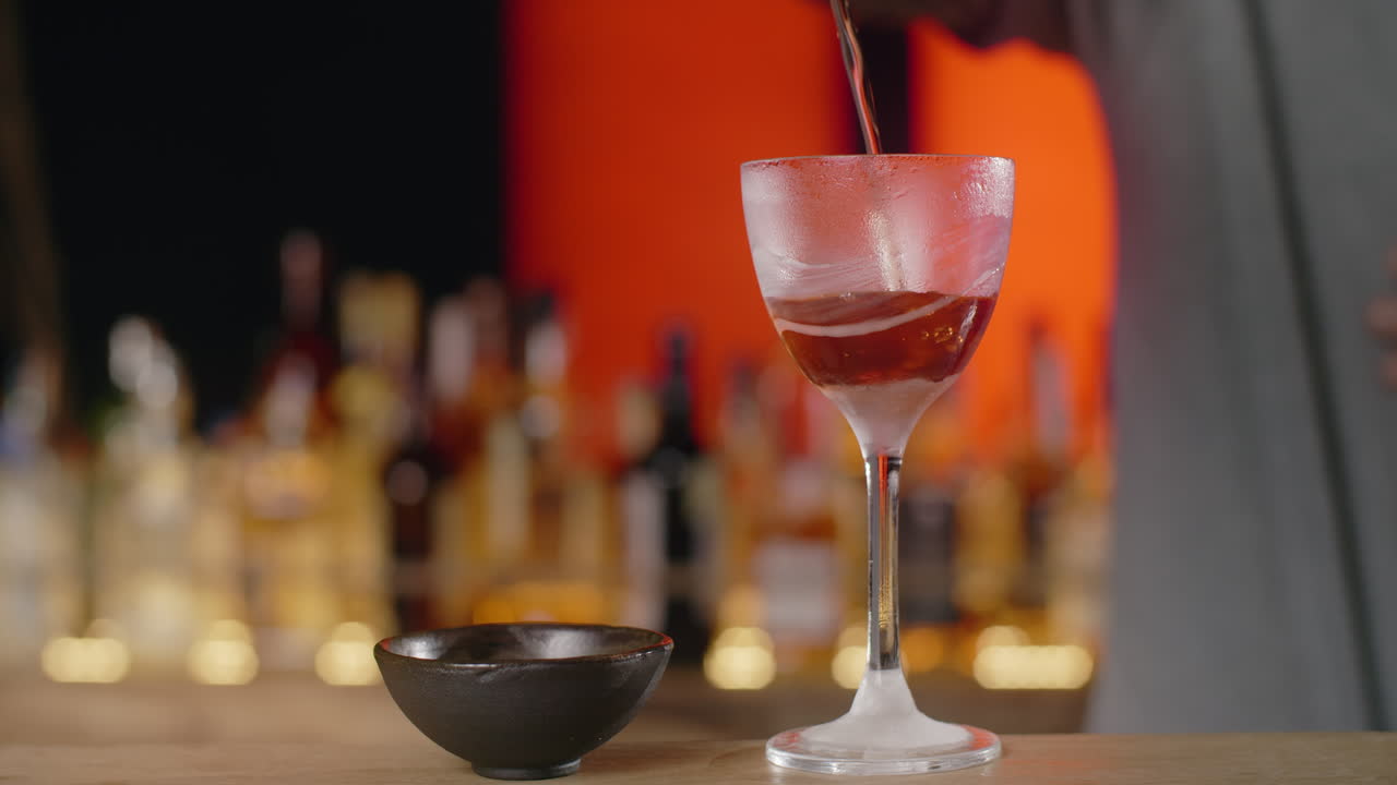 カクテルを注ぐバーテンダー