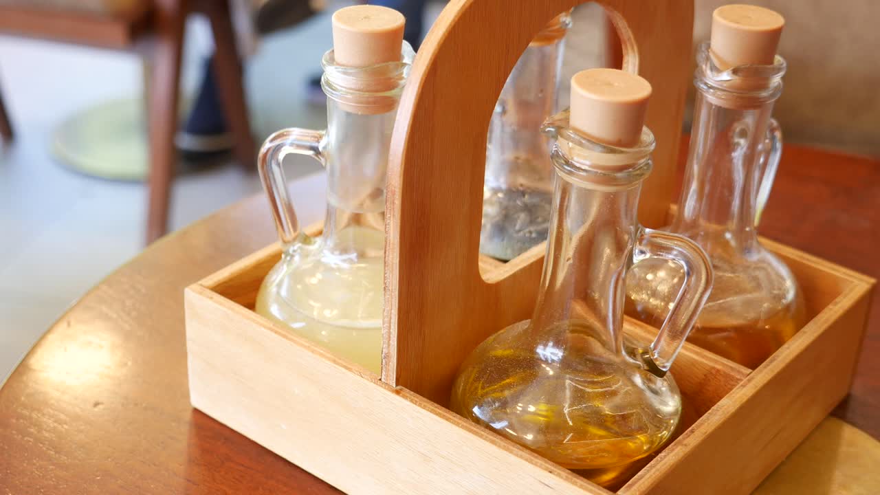 Vassoio di legno con bottiglie di vetro di olio e aceto