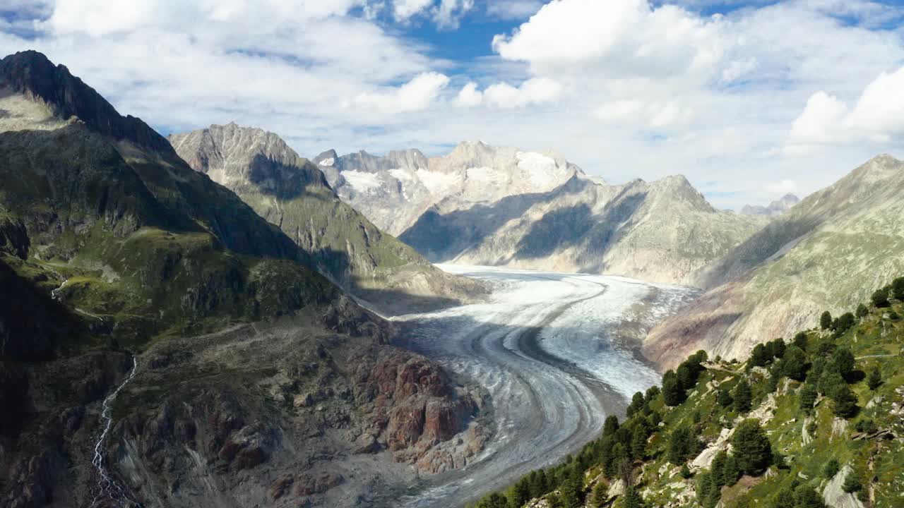 drone filmado sobre el enorme glaciar de aletsch en los alpes suizos con paisaje de montaña por clima nublado