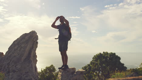 fit active man hiking, standing on a mountain peak