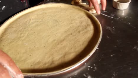 close up, top view of a female chef hands removing the over lefts of a pizza dough