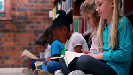 pupils sitting in a row reading in the library