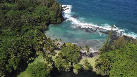 Großer-Inselschwarzer-Sandstrand-Mit-Brandung,-Die-Auf-Felsen-In-Hawaii-Bricht