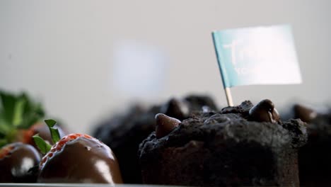 Chocolate-covered-strawberries-and-beet-infused-muffins-spinning-on-a-lazy-susan-with-the-background-out-of-focus