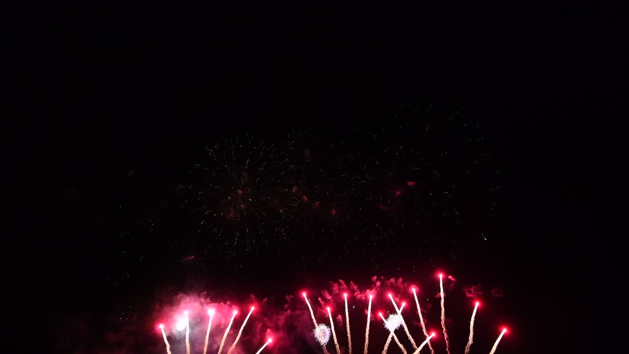 Loop seamless of real fireworks with abstract blur bokeh lights in night sky. Glowing fireworks festival. New year's eve 2022 fireworks celebration