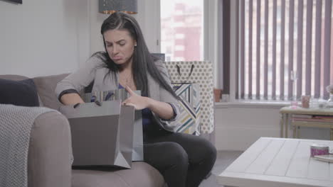 Slow-Motion-Shot-Of-Young-Beautiful-Woman-Looking-Through-Her-Shopping-Bags-Only-To-Realise-That-She-Has-Forgotten-Something,-Then-Uses-Her-Smart-Phone-To-Order-The-Missing-Product---Ungraded