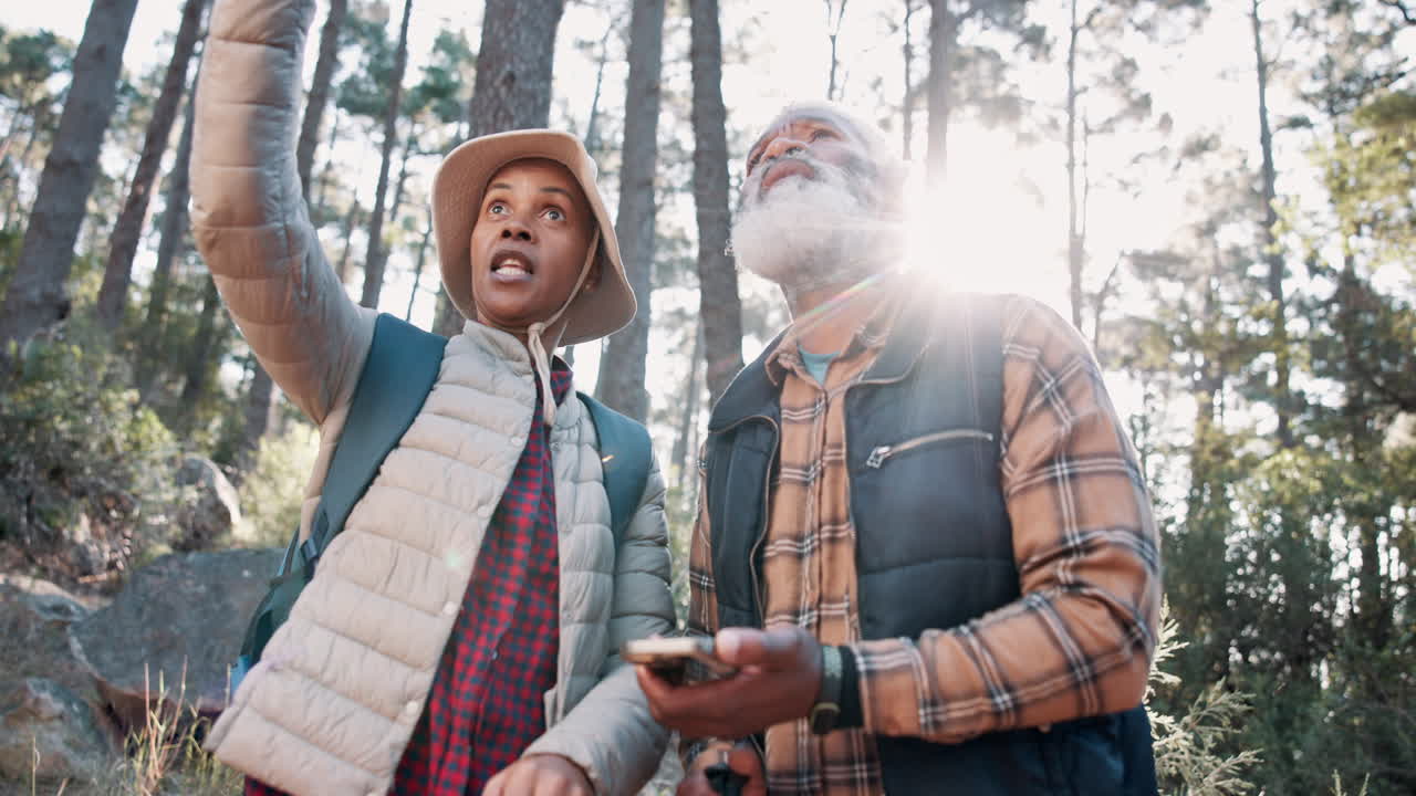 한 부부가 숲에서 스마트폰을 사용하면서 산책하고 있습니다.