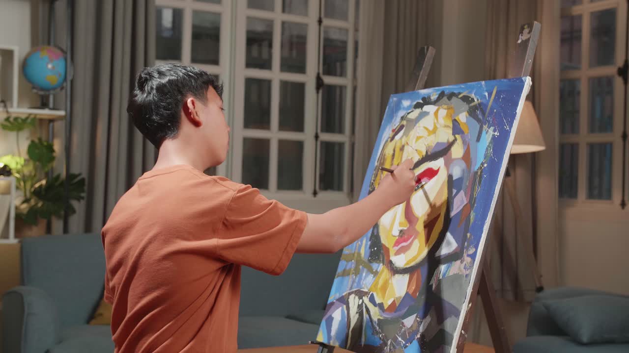 Medium Shot Side View Of An Asian Artist Boy Holding Paintbrush Mixed Colour And Thinking Before Painting A Girl'S Hair On The Canvas